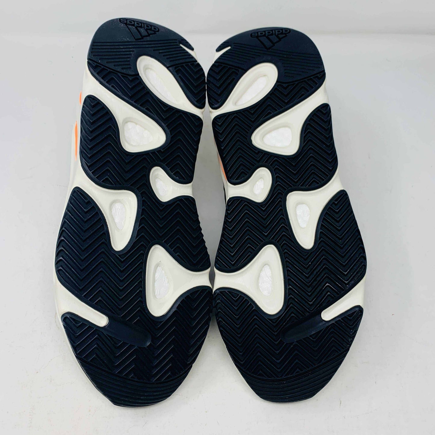 A Yeezy 700 Waverunner with a multicolor scheme of gray, black, teal, and orange rests on a Yeezy Boost 700 Made by Adidas box. Sales are final on these authentic shoes.