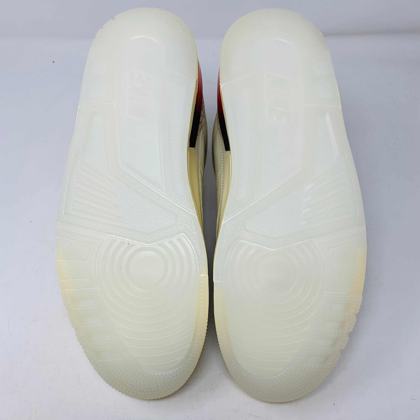 The Jordan 3 Retro SP J Balvin Medellín Sunset sneakers feature transparent, textured soles with the Jordan logo embossed, shown upside down against a plain background.