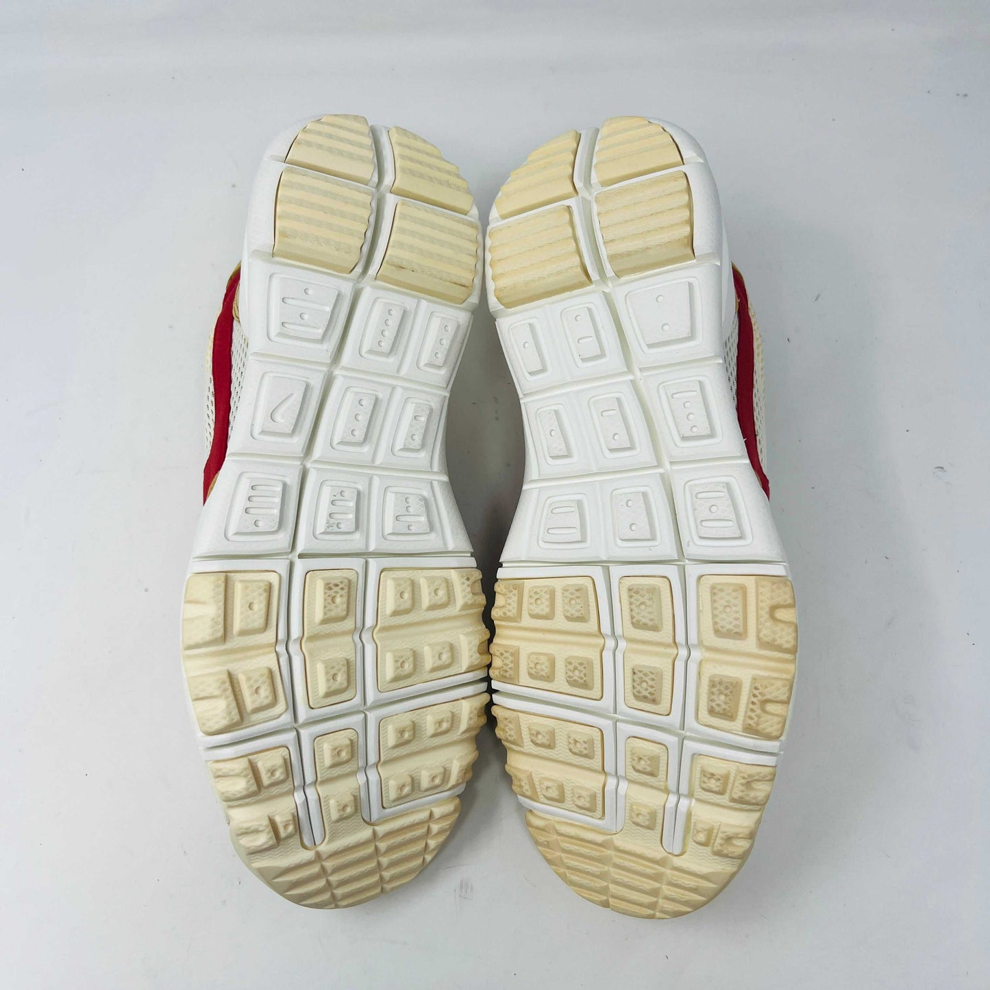 The NikeCraft Mars Yard Shoe 2.0 by Tom Sachs Space Camp features white mesh, tan suede accents, red Nike logos on the tongues, red heel pull tabs, and white laces. This 100% authentic sneaker is perfect for elevating any outfit with style.