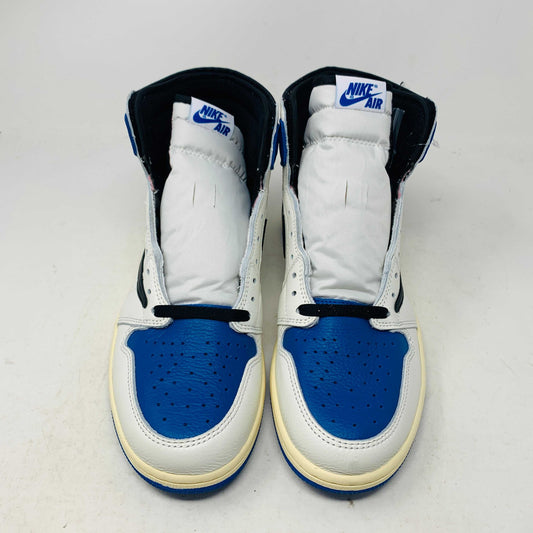 The Jordan 1 Retro High OG SP Fragment x Travis Scott is a new high-top sneaker featuring a blue, white, and black design with a unique backward Nike swoosh. It comes in a transparent, branded box adorned with butterfly and text details, boasting a thick sole and classic 1985 Air Jordan design.