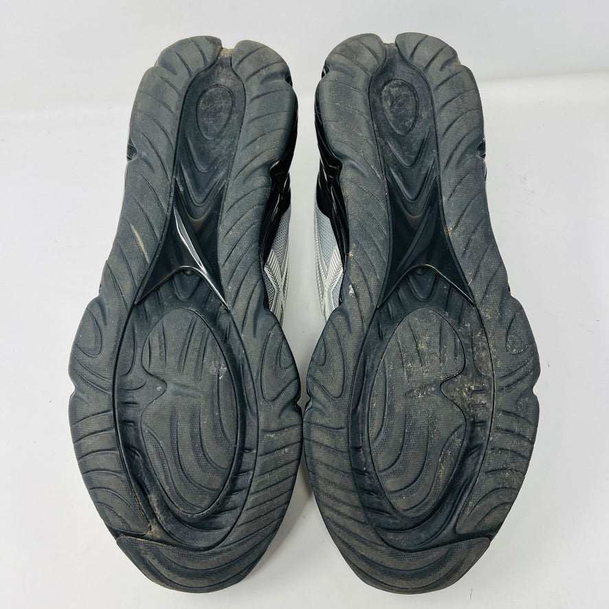 A side view of the ASICS Gel-Quantum 360 VIII C.P. Company in Cement Grey, featuring a sleek modern design with gray and silver elements, black accents, a black sole, and subtle patterns on its clean upper. The background is plain white.