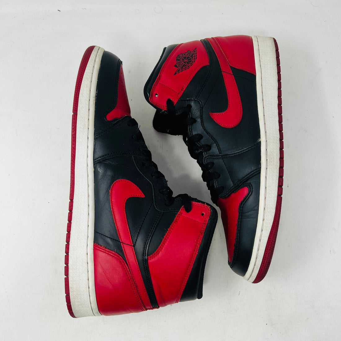 Pair of black and red Air Jordan 1 High OG sneakers on white background