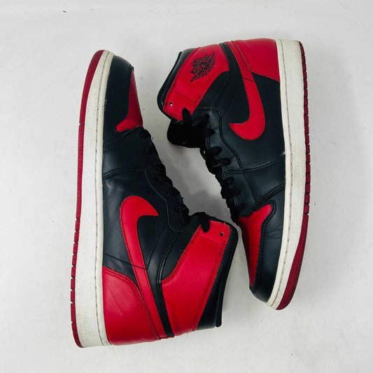 Pair of black and red Air Jordan 1 High OG sneakers on white background