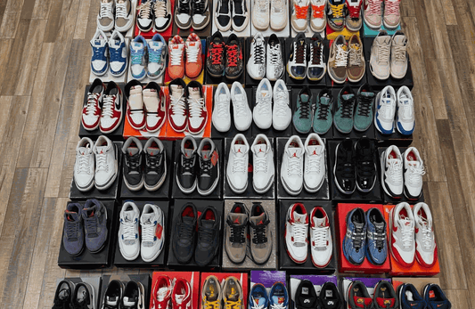 Array of Jordans, Nikes, and Travis Scott sneakers neatly arranged on wooden floor with boxes, showcasing ultimate sneaker sizing guide options