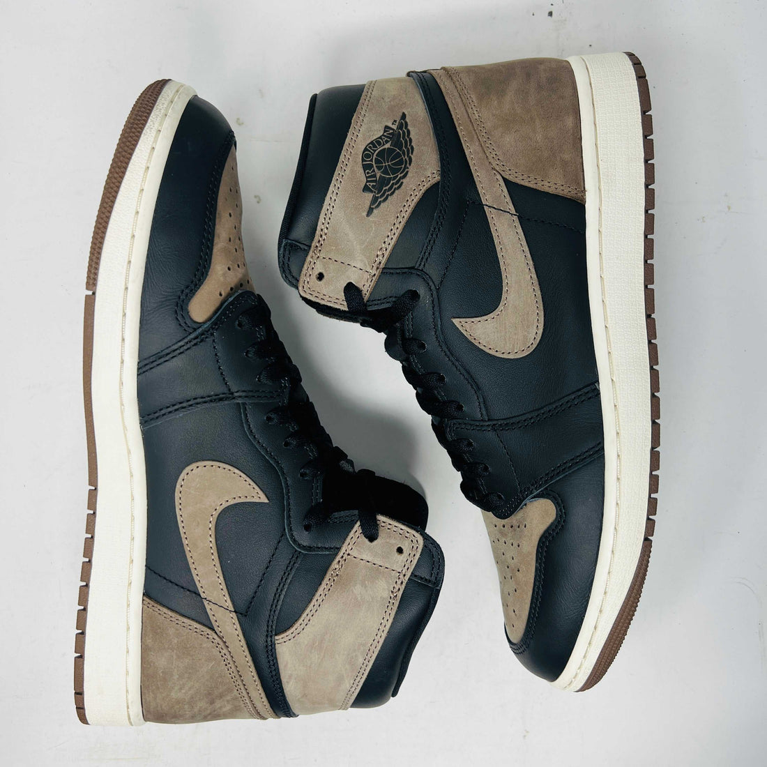 Pre-owned Air Jordan 1 sneakers in black and brown with white midsoles, popular for style and resale value.