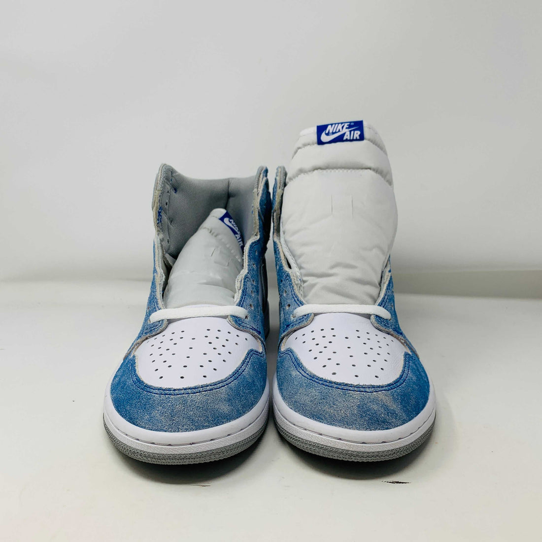 Pair of white and blue Nike Air sneakers front view on white background