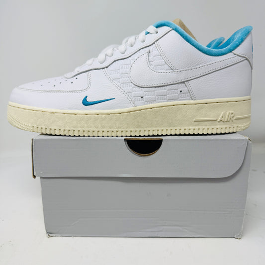 Introducing the Nike Air Force 1 Low Kith Hawaii sneaker: a fresh white design with white laces, light blue inner lining, teal swoosh, textured pattern, and cream-colored sole. Packaged in a gray shoebox, it features the word AIR embossed on the side.