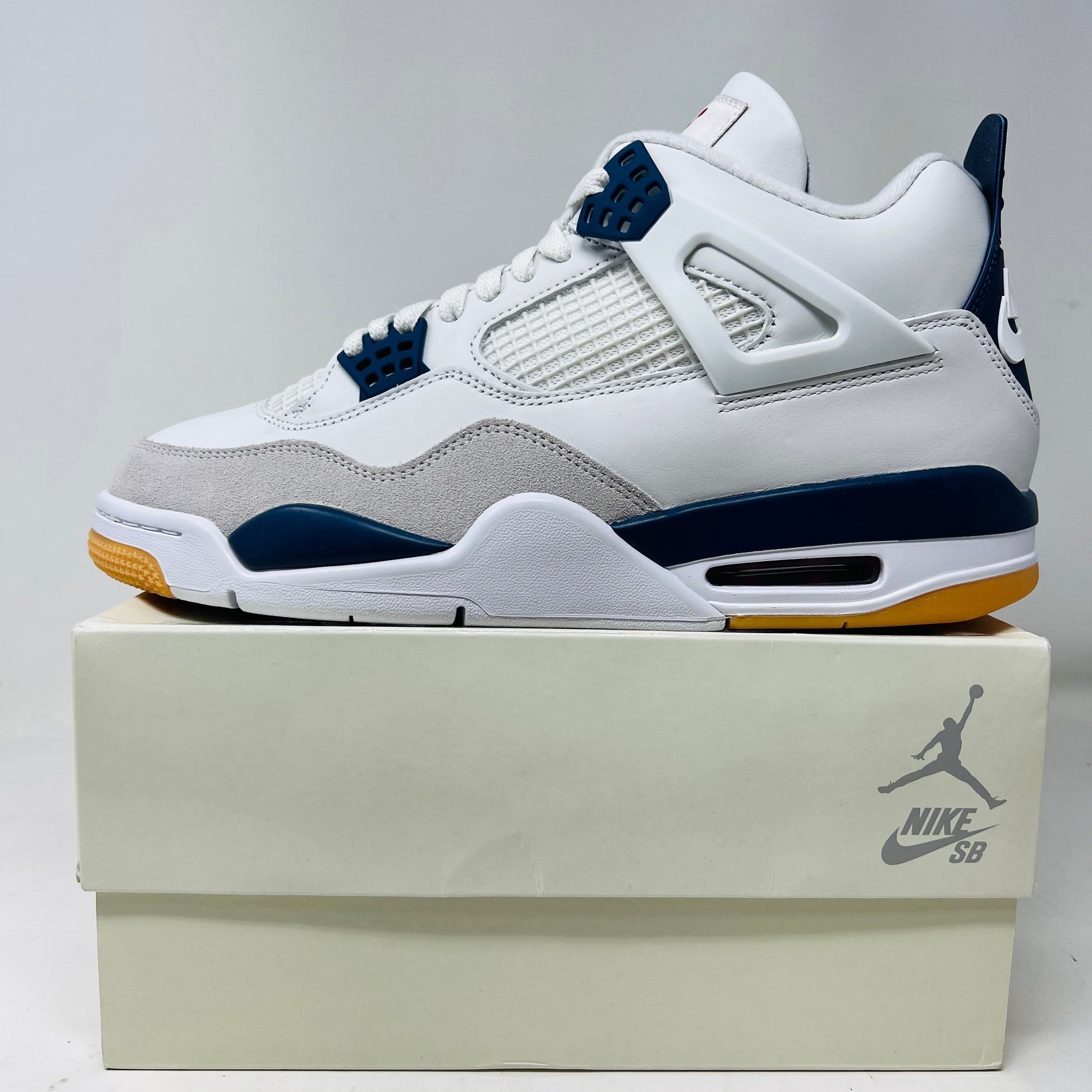 Jordan 4 Retro SB Navy sneakers, brand new 2025 release, displayed on a box.