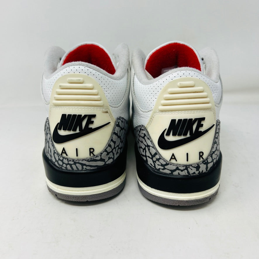 The Jordan 3 Retro White Cement Reimagined sneakers by Jordan feature a clean white upper with red accents, gray and black patterned trim on the toe and heel, white laces, and a red logo on the tongue, displayed upright on a pristine white background—perfect for everyday wear.
