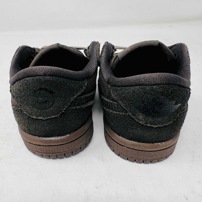 A Jordan 1 Retro Low OG SP Travis Scott Velvet Brown (TD) sneaker with a unique swoosh design sits on a white shoebox. It includes extra pink and black laces, is 100% authentic, brand new, and ready to elevate your style with its sleek look.