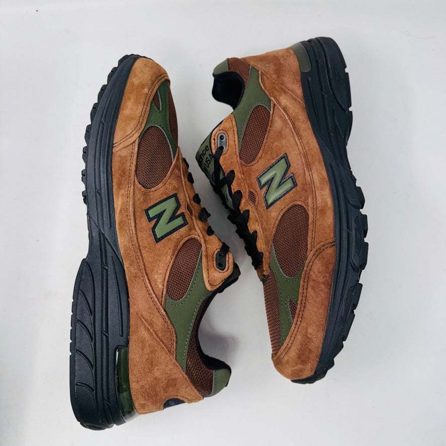 The New Balance 993 Aime Leon Dore Brown sneakers feature a brown and green color scheme with black laces, New Balance Made in USA on the tongue, and are crafted from suede and mesh materials for a sleek look.