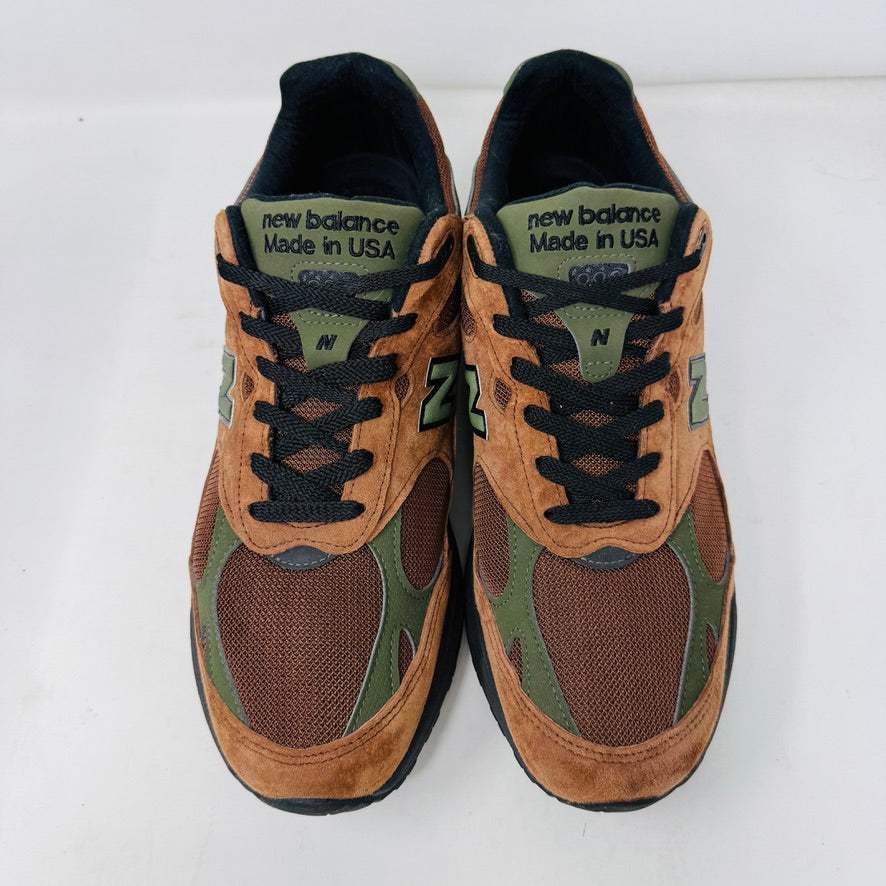 The New Balance 993 Aime Leon Dore Brown sneakers feature a brown and green color scheme with black laces, New Balance Made in USA on the tongue, and are crafted from suede and mesh materials for a sleek look.