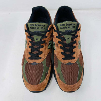 The New Balance 993 Aime Leon Dore Brown sneakers feature a brown and green color scheme with black laces, New Balance Made in USA on the tongue, and are crafted from suede and mesh materials for a sleek look.