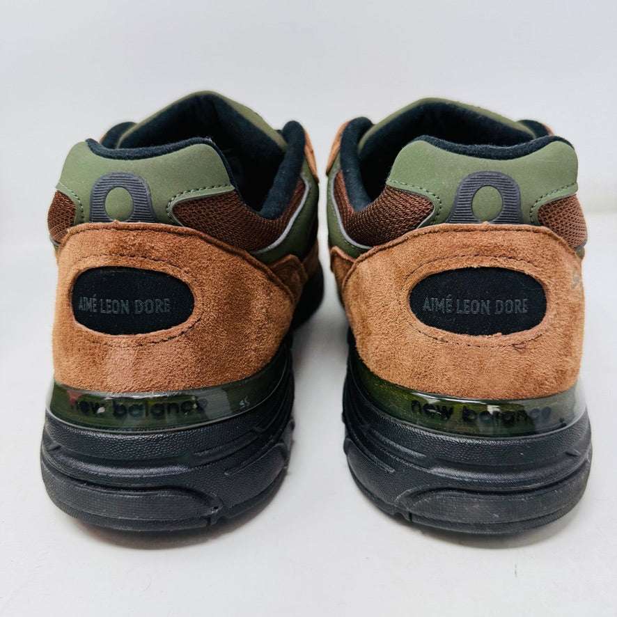 The New Balance 993 Aime Leon Dore Brown sneakers feature a brown and green color scheme with black laces, New Balance Made in USA on the tongue, and are crafted from suede and mesh materials for a sleek look.