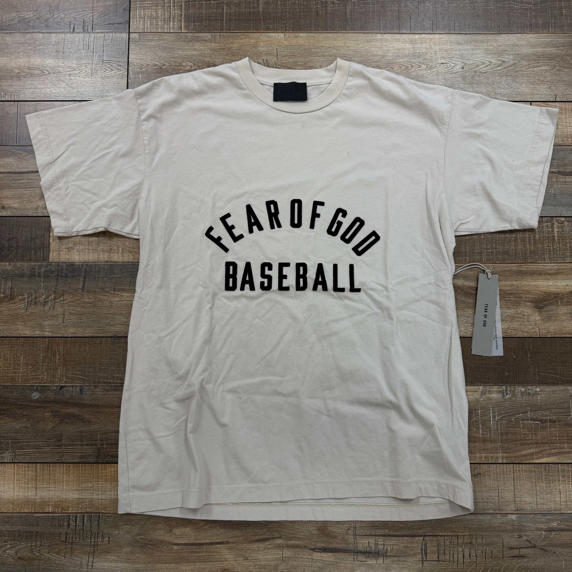 Fear of God Baseball T-shirt in beige with bold lettering on front, brand new condition.