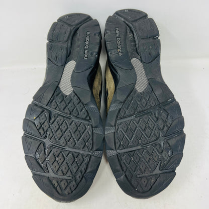 The New Balance 990v3 MiUSA JJJJound Brown Black athletic shoe, released in 2022, features tan and black mesh-suede uppers with an N logo on the side and 990 on the heel. It sits atop a black shoebox with the label M990JJ3 and shows light wear.