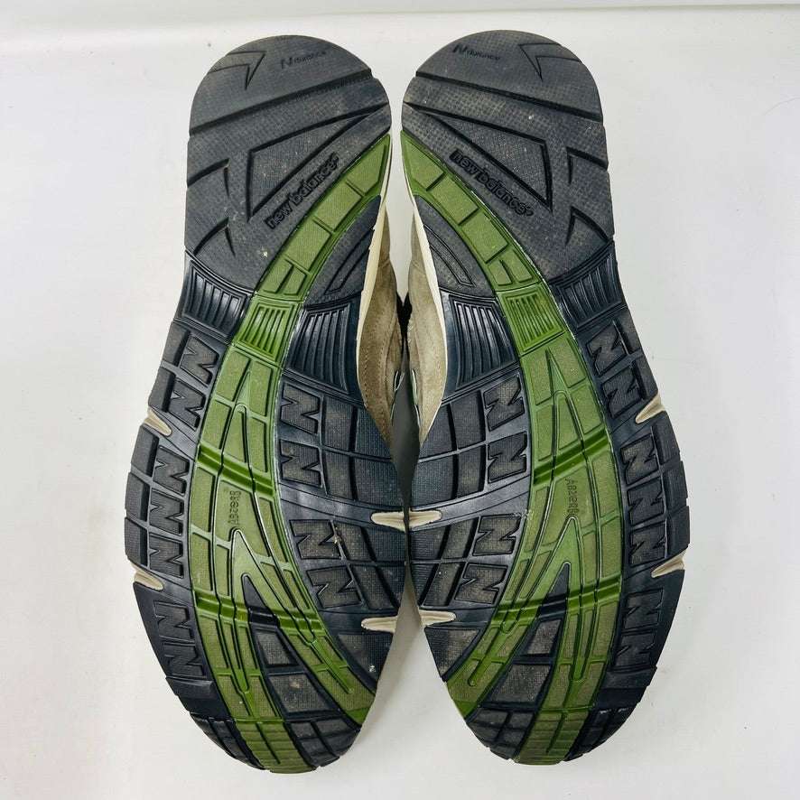 A pair of Holy Grounds New Balance 991 Aime Leon Dore MiUK Grey sneakers in gray, green, and beige are displayed on their shoebox. Comes with extra green and gray laces. The 2022 box details the size and model.