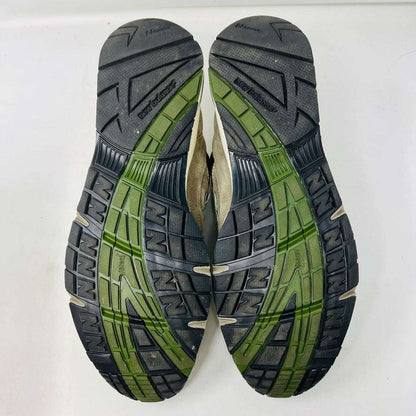 A pair of Holy Grounds New Balance 991 Aime Leon Dore MiUK Grey sneakers in gray, green, and beige are displayed on their shoebox. Comes with extra green and gray laces. The 2022 box details the size and model.