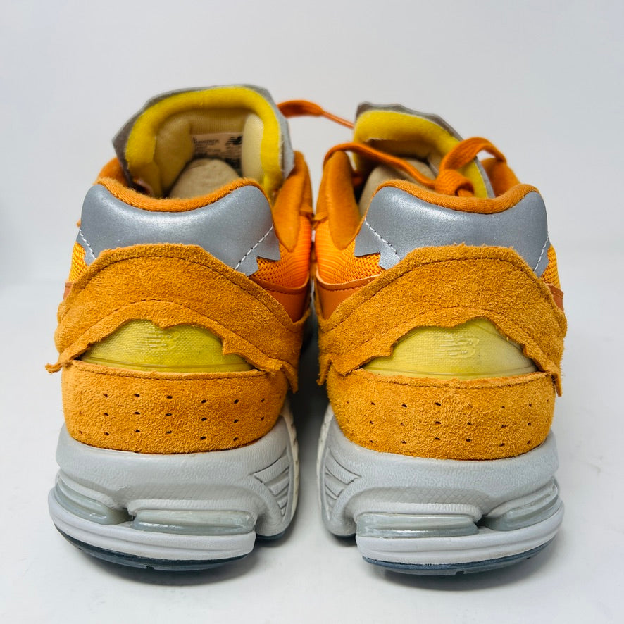 Brand new New Balance 2002R Protection Pack sneakers in Vintage Orange sit on their box, featuring a suede and mesh design, white N logo on sides, gray and white sole. Box in pristine condition with label for mens size 10.5, UK size 9.5.