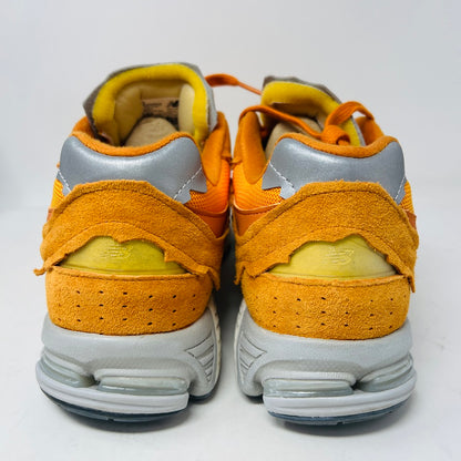 Brand new New Balance 2002R Protection Pack sneakers in Vintage Orange sit on their box, featuring a suede and mesh design, white N logo on sides, gray and white sole. Box in pristine condition with label for mens size 10.5, UK size 9.5.