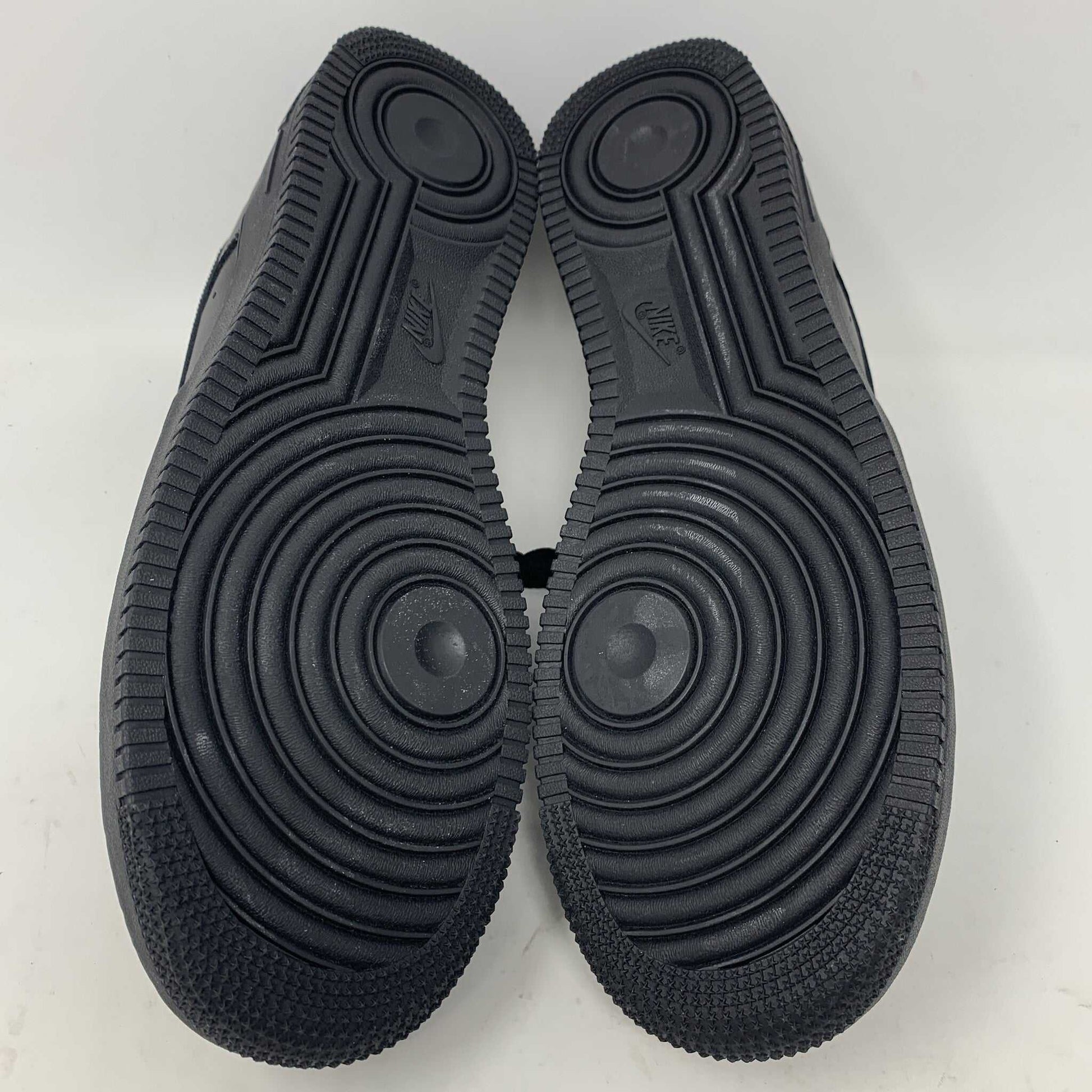 The Nike Supreme Air Force 1 Black features a perforated design on the toe box, black supreme laces with a shiny tag, and a prominent Nike logo, all set against a plain white background.