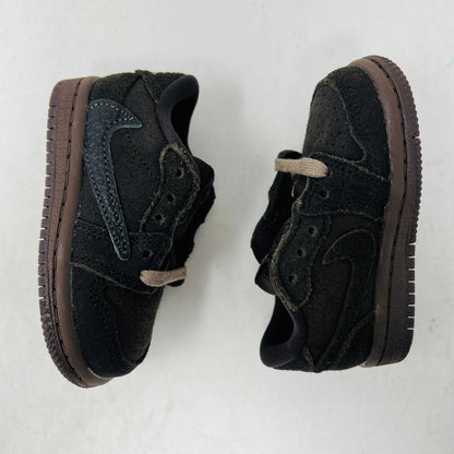 A Jordan 1 Retro Low OG SP Travis Scott Velvet Brown (TD) sneaker with a unique swoosh design sits on a white shoebox. It includes extra pink and black laces, is 100% authentic, brand new, and ready to elevate your style with its sleek look.