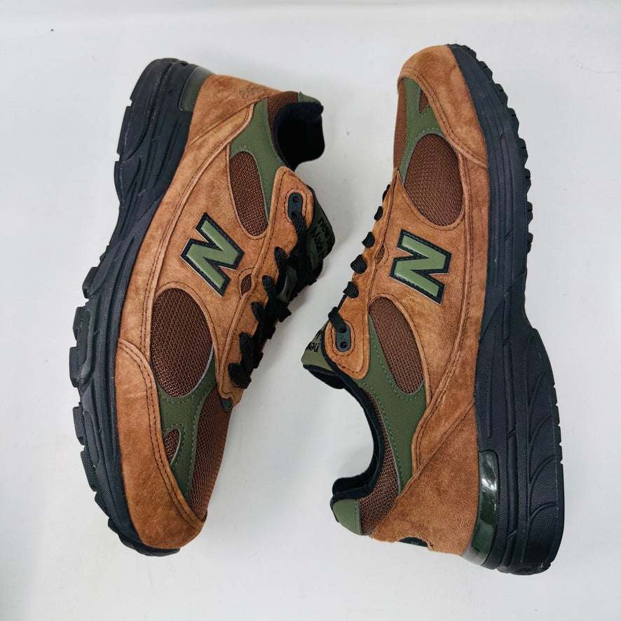 The New Balance 993 Aime Leon Dore Brown sneakers feature a brown and green color scheme with black laces, New Balance Made in USA on the tongue, and are crafted from suede and mesh materials for a sleek look.
