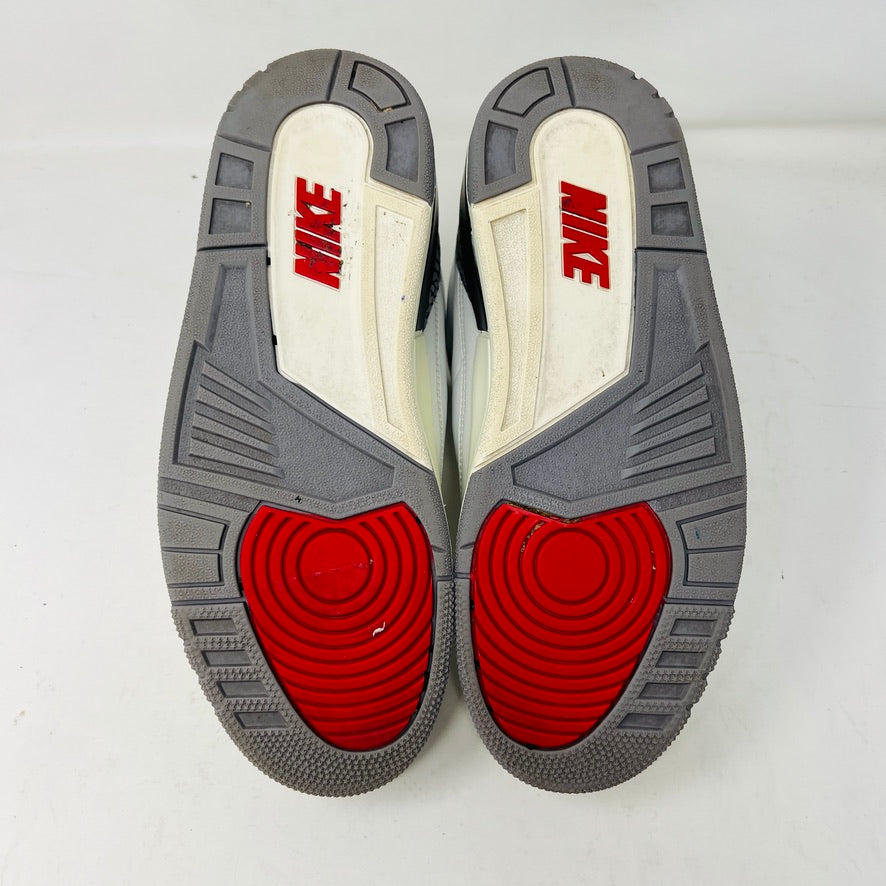 The Jordan 3 Retro White Cement Reimagined sneakers by Jordan feature a clean white upper with red accents, gray and black patterned trim on the toe and heel, white laces, and a red logo on the tongue, displayed upright on a pristine white background—perfect for everyday wear.
