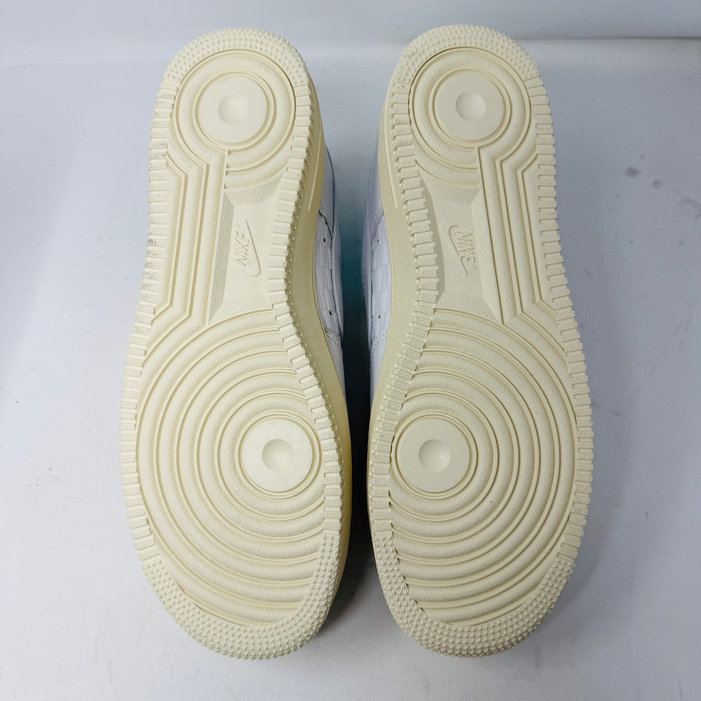 Introducing the Nike Air Force 1 Low Kith Hawaii sneaker: a fresh white design with white laces, light blue inner lining, teal swoosh, textured pattern, and cream-colored sole. Packaged in a gray shoebox, it features the word AIR embossed on the side.