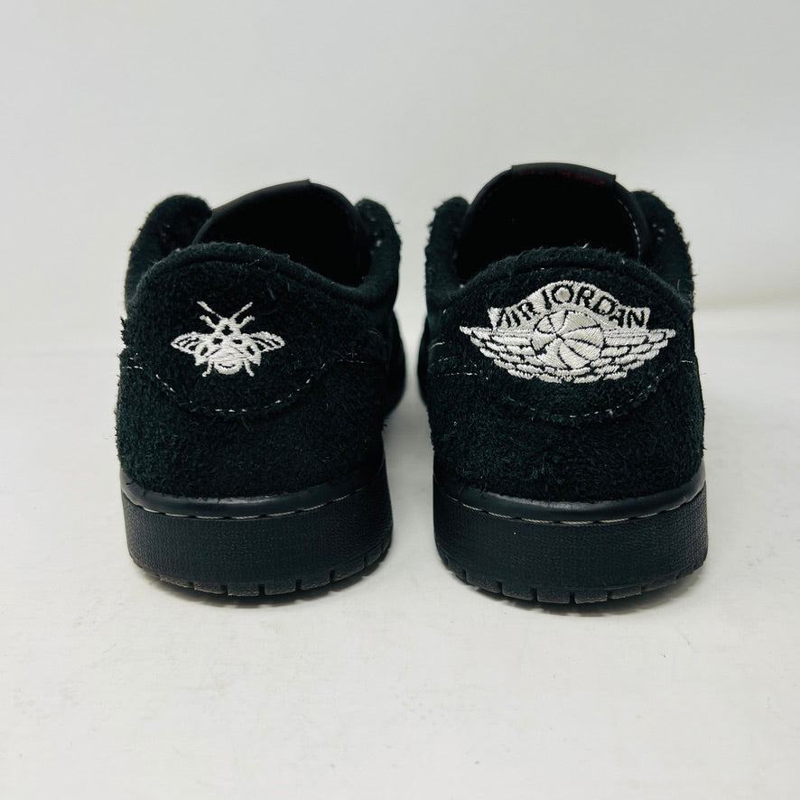 The Jordan 1 Retro Low OG SP Travis Scott Black Phantom sneaker, featured on a Nike box, flaunts black suede with a clean upper and white swoosh. Size info: US 9.5, Euro 43, UK 8.5, CM 27.5—ideal for general wear due to its visible stitching design.
