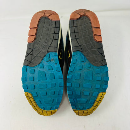 The Nike Air Max 1/97 Sean Wotherspoon sneakers showcase a colorful upper with hues of yellow, blue, and pink. They include extra blue and white laces and come in a red box labeled with size 9.5.