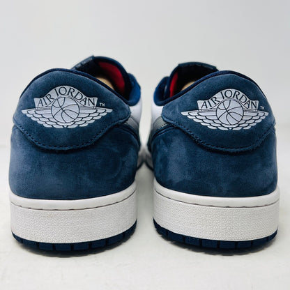 The Jordan 1 Low SB Midnight Navy sneakers, with white and navy panels and a side Nike swoosh, are displayed on a pristine shoebox. A spare set of white laces featuring the Nike SB logo in Metallic Silver is also included.