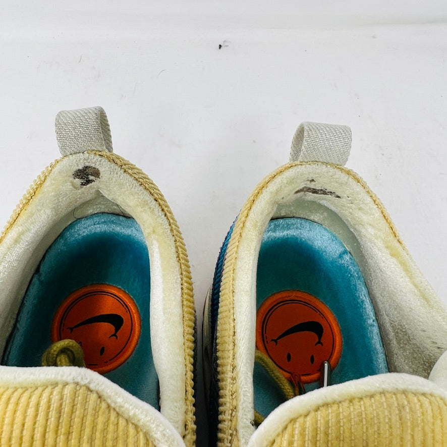 The Nike Air Max 1/97 Sean Wotherspoon sneakers showcase a colorful upper with hues of yellow, blue, and pink. They include extra blue and white laces and come in a red box labeled with size 9.5.