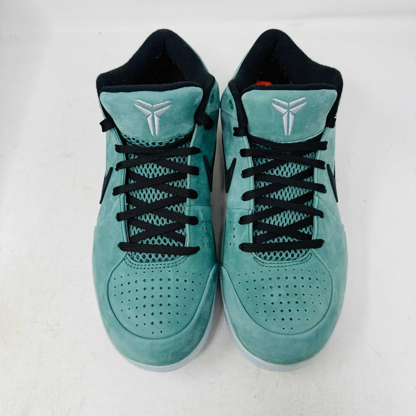 Green Nike Kobe 4 Protro Girl Dad basketball shoe with a black swoosh, silver heel accent, and suede finish sits atop a Nike shoebox. In 9/10 condition and worn once, the label indicates size 9.5 US with additional sizing details for these authentic shoes.