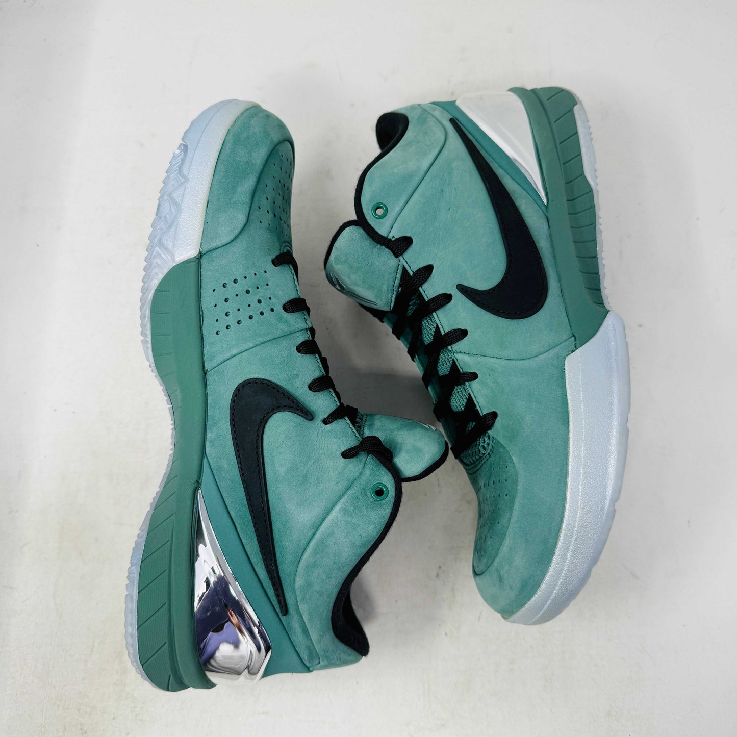 Green Nike Kobe 4 Protro Girl Dad basketball shoe with a black swoosh, silver heel accent, and suede finish sits atop a Nike shoebox. In 9/10 condition and worn once, the label indicates size 9.5 US with additional sizing details for these authentic shoes.