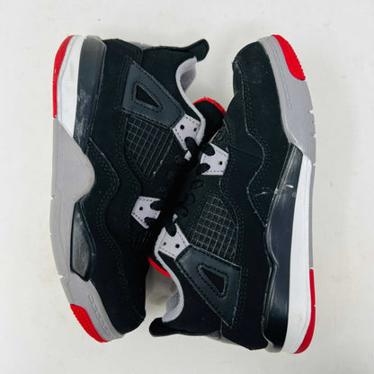 The Jordan 4 Retro Bred (2019) (PS) in black and red, featuring clean uppers with a white midsole and gray accents, sits on its original black shoebox. The box displays size, product details, and the iconic Jumpman logo, underscoring these authentic shoes from Jordans 2019 collection.