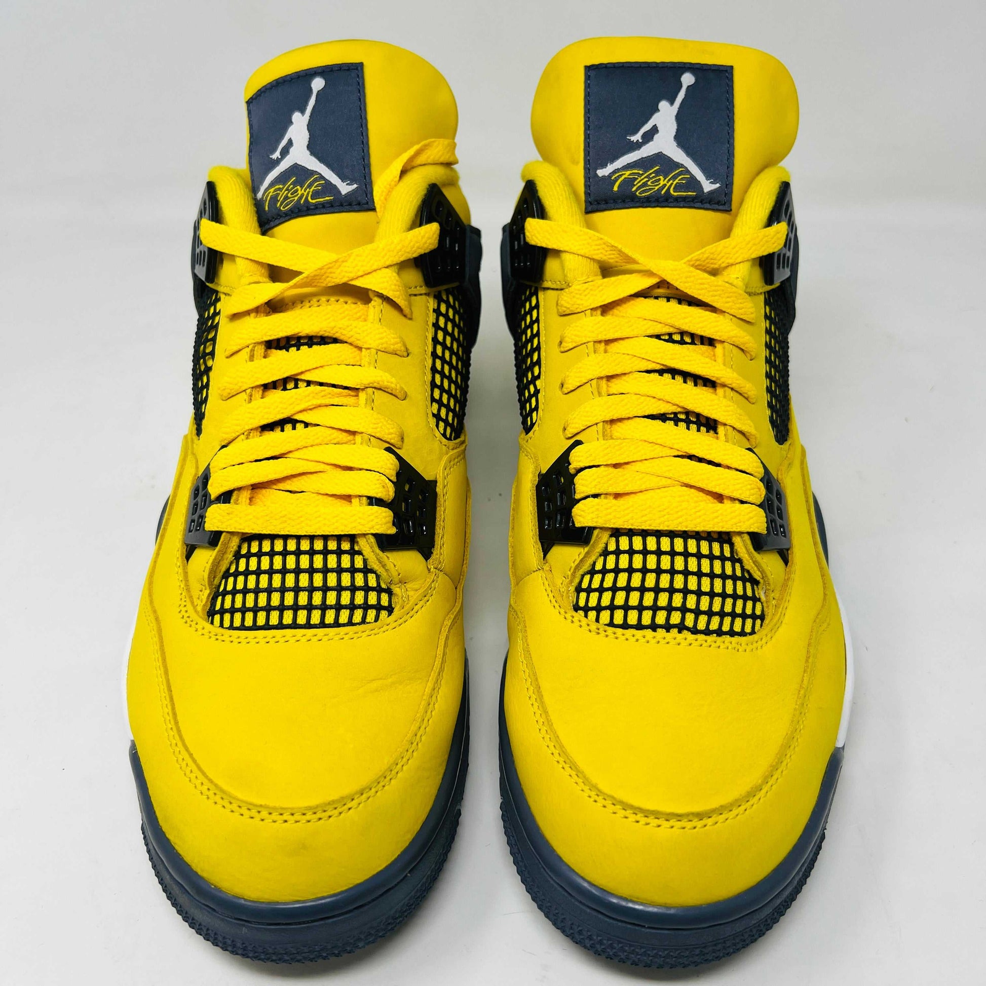 The Jordan 4 Retro Lightning (2021) in yellow rests on its matching box with a size label. Featuring clean uppers, blue accents, a visible air unit in the heel, and a black Jumpman logo on the box, note that returns are not accepted.