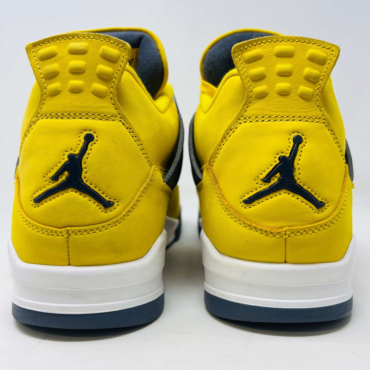 The Jordan 4 Retro Lightning (2021) in yellow rests on its matching box with a size label. Featuring clean uppers, blue accents, a visible air unit in the heel, and a black Jumpman logo on the box, note that returns are not accepted.