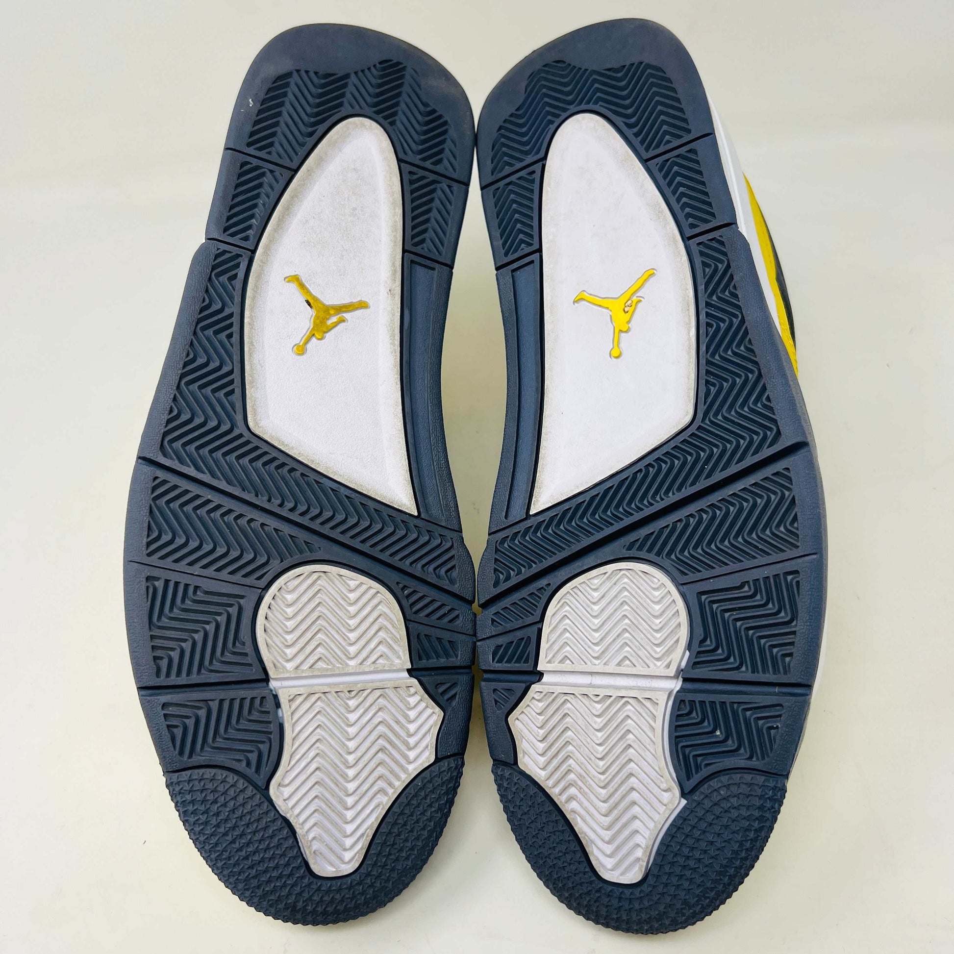The Jordan 4 Retro Lightning (2021) in yellow rests on its matching box with a size label. Featuring clean uppers, blue accents, a visible air unit in the heel, and a black Jumpman logo on the box, note that returns are not accepted.