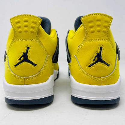 The Jordan 4 Retro Lightning (2021) (GS) sneaker, in bright yellow with black/gray accents and a visible air unit, is displayed on its matching shoebox. Both the box and heel sport the iconic Jumpman logo, with size details confirming authenticity from the Jordan brand.