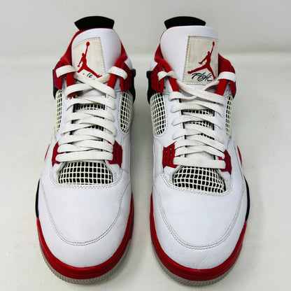 The Jordan 4 Retro Fire Red (2020) sneaker features a white leather upper with red accents, black netting, and a visible Air unit. It rests atop a matching Nike Air branded shoebox, with branding also on the shoe heel.