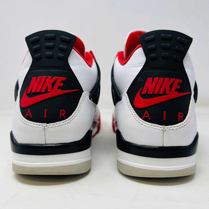 The Jordan 4 Retro Fire Red (2020) sneaker features a white leather upper with red accents, black netting, and a visible Air unit. It rests atop a matching Nike Air branded shoebox, with branding also on the shoe heel.