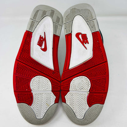 The Jordan 4 Retro Fire Red (2020) sneaker features a white leather upper with red accents, black netting, and a visible Air unit. It rests atop a matching Nike Air branded shoebox, with branding also on the shoe heel.