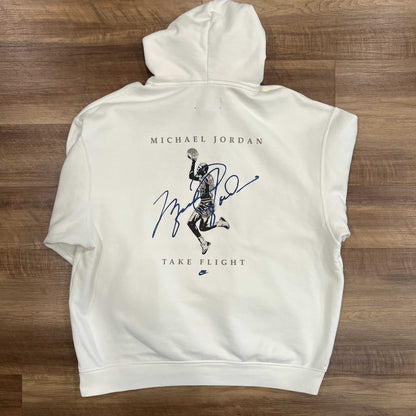 Preowned Air Jordan Flight Signature Hoodie in white, size XXL, features front pocket and blue text reading AIR JORDAN and COLLECTION with a graphic on the upper chest. Includes blue text on the left sleeve. Displayed on a wooden floor. Brand: Jordan.