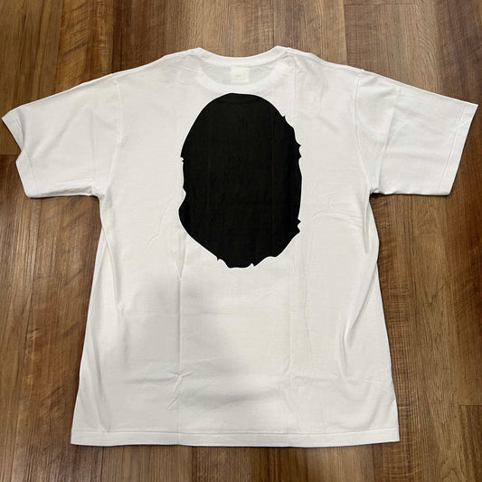 White BAPE Head Tee in XL, brand new condition, showing back design on wood floor.