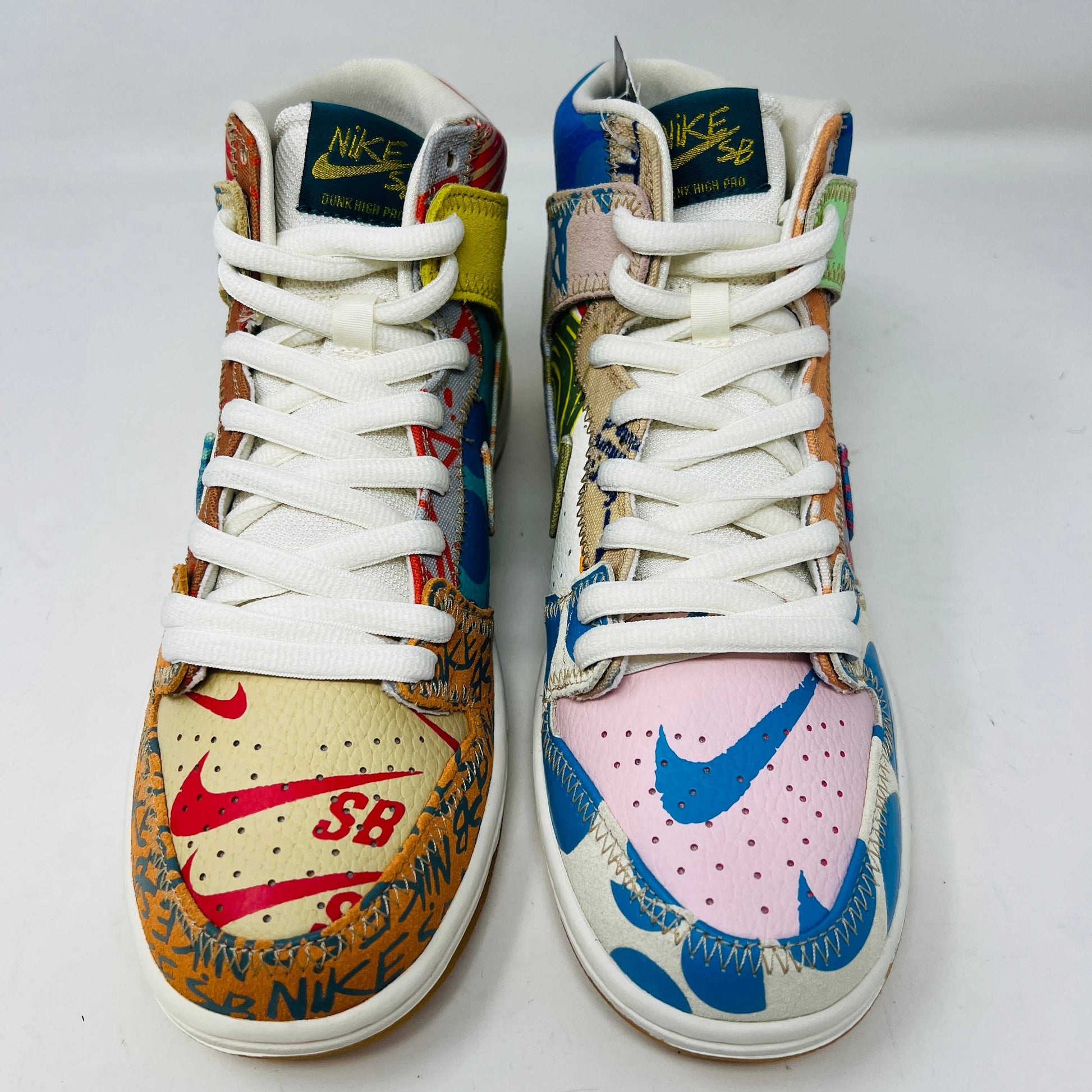 The Nike SB Dunk High Thomas Campbell What The Dunk, a colorful high-top sneaker, features a mix of patterns and textures with a blue Nike logo. It is on a teal SB box, BRAND NEW and 100% Authentic. An orange lace lies beside this shoe featuring blue, green, pink, and tan elements.