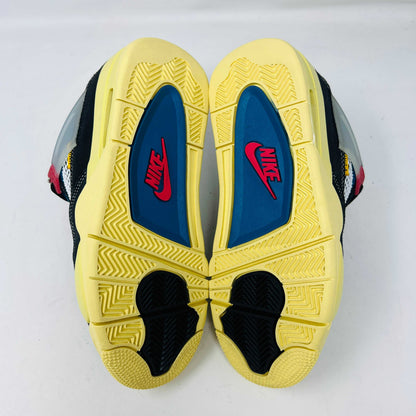 Displayed on their box, the 100% authentic Jordan 4 Retro Union Off Noir sneakers from the Jordan brand showcase clean black uppers, a yellow sole, blue accents, and feature a clear hang tag with a white Jumpman logo. Yellow extra laces are also placed on the box.