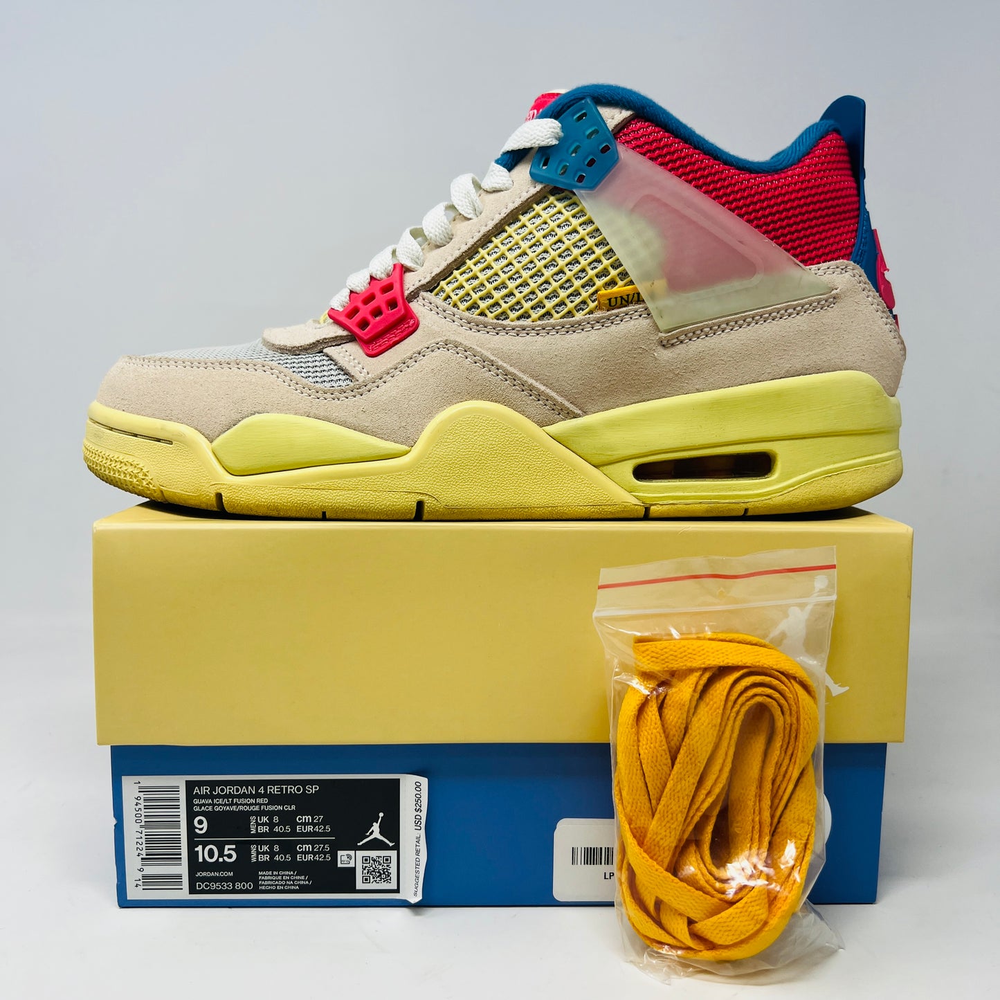 The Jordan 4 Retro Union Guava Ice sneaker from Jordan features a vibrant mix of beige, yellow, blue, and red on its clean uppers. It includes extra yellow laces packaged in a plastic bag alongside the shoe box.