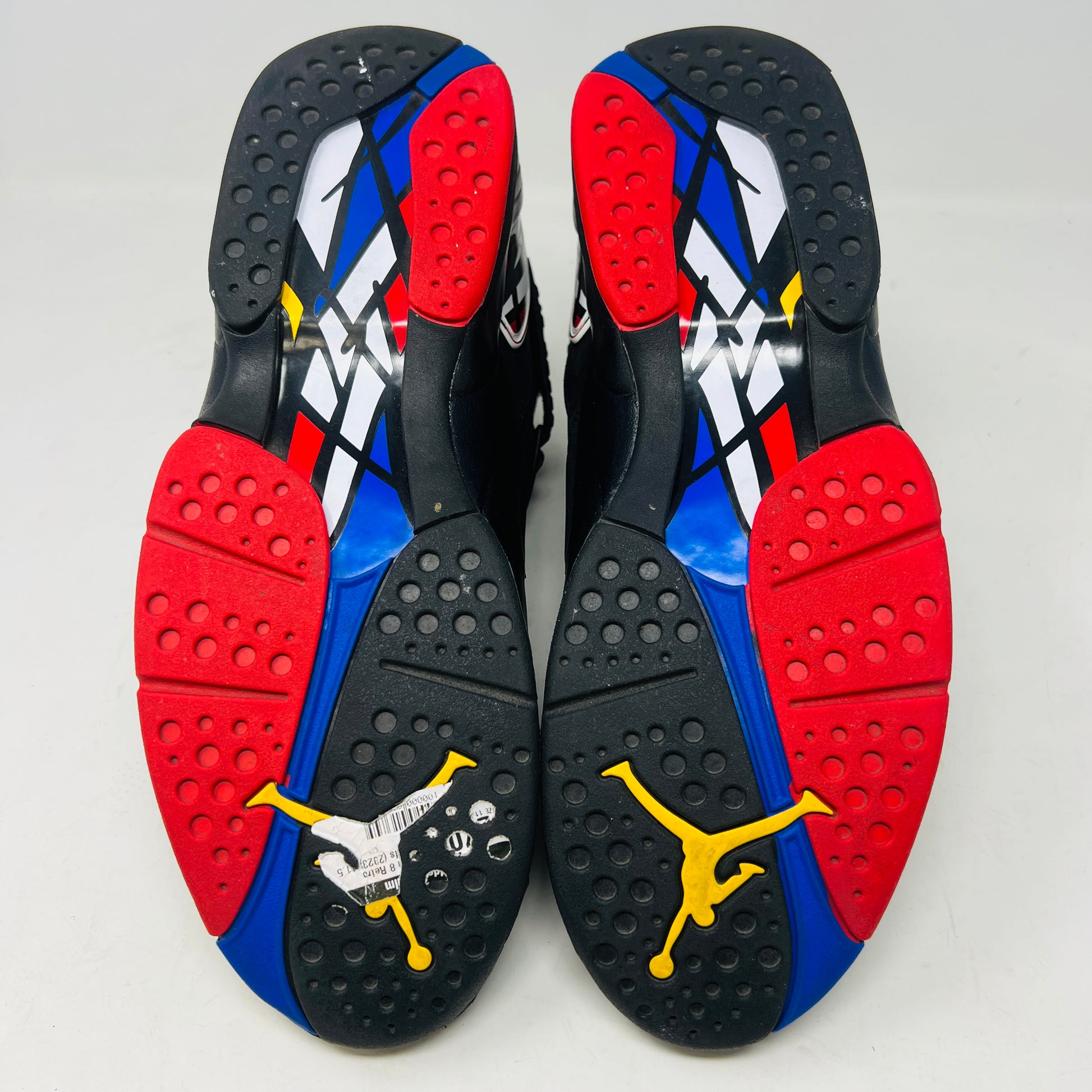 A Jordan 8 Retro Playoffs (2023) shoe, black and red with gray/red accents, features a high-top design with a strap, textured sole with blue hints, and clean uppers. Displayed on its Nike Air box in good condition, the label reveals size and Jordan brand details.