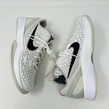 The fresh white Nike Kobe 6 Sail All-Star (GS) athletic shoe, showcasing a textured design and black swoosh logo, is presented on an orange box. Inside are plastic-wrapped accessories and extra laces for versatile style in 2024.